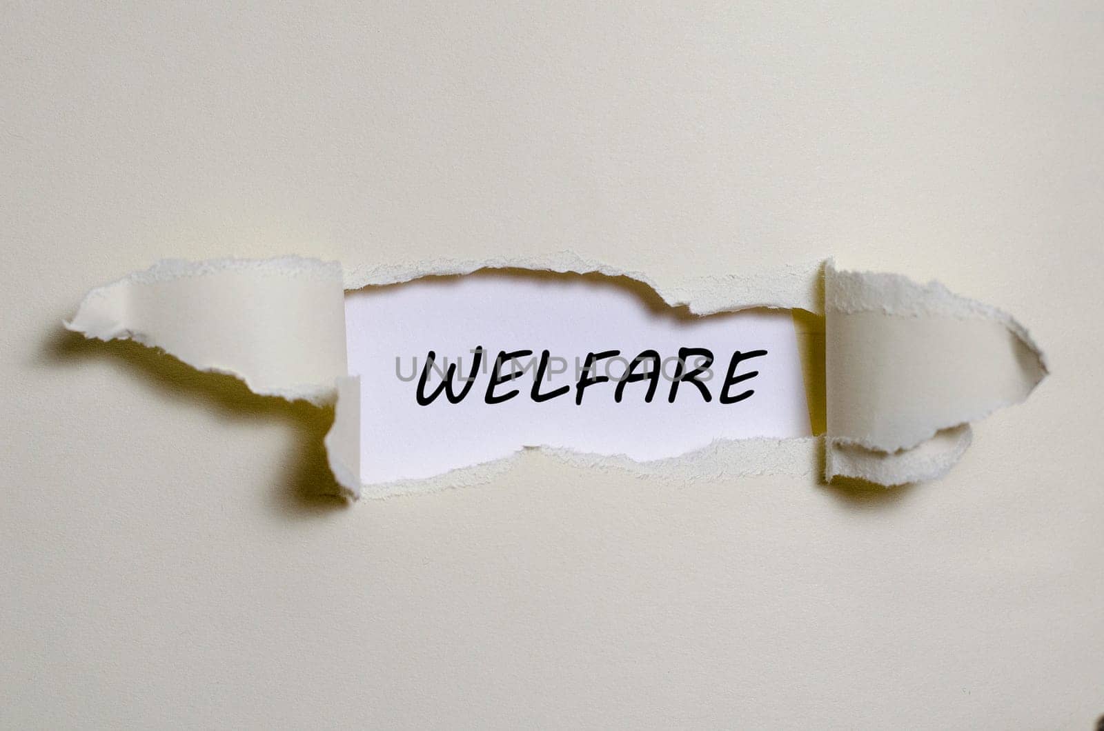 The word welfare appearing behind torn paper
