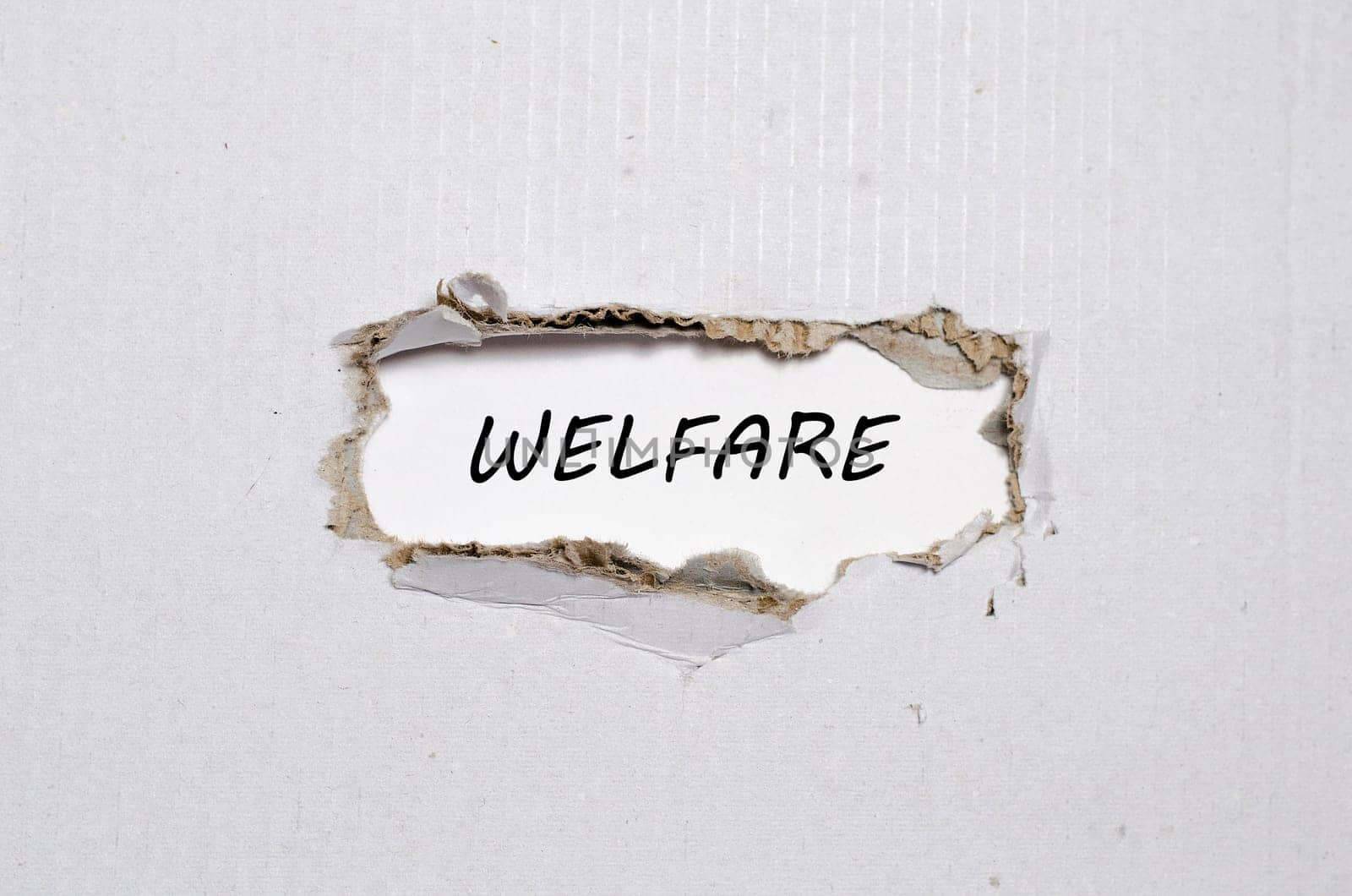The word welfare appearing behind torn paper