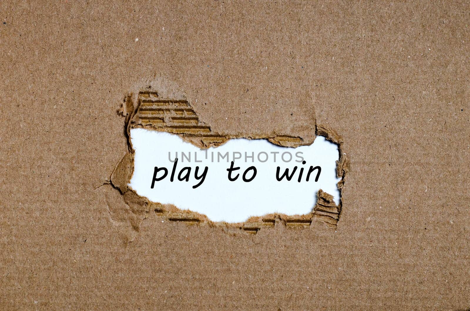 The word play to win appearing behind torn paper