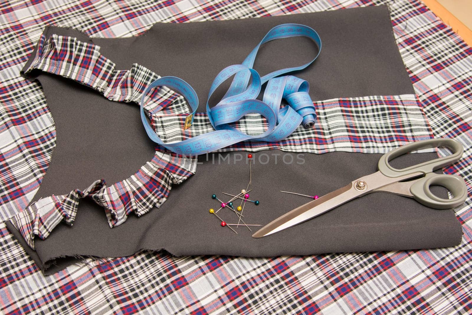 Top view of the child billet school dress lying on the table with sewing accessories