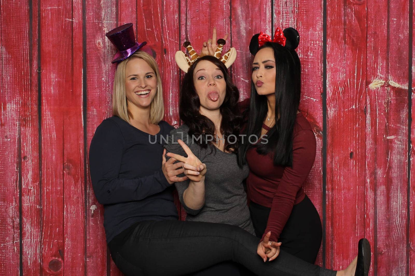 Cheeky girls goofy in front of a photo booth