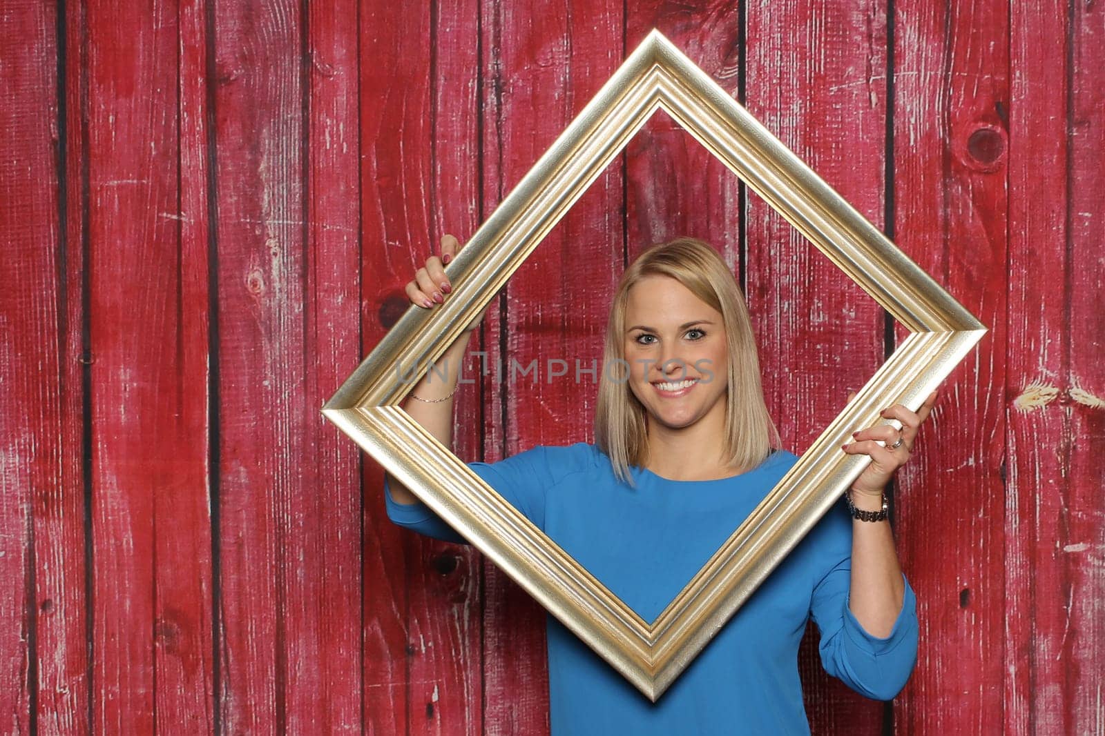 Blonde girl looks through a picture frame