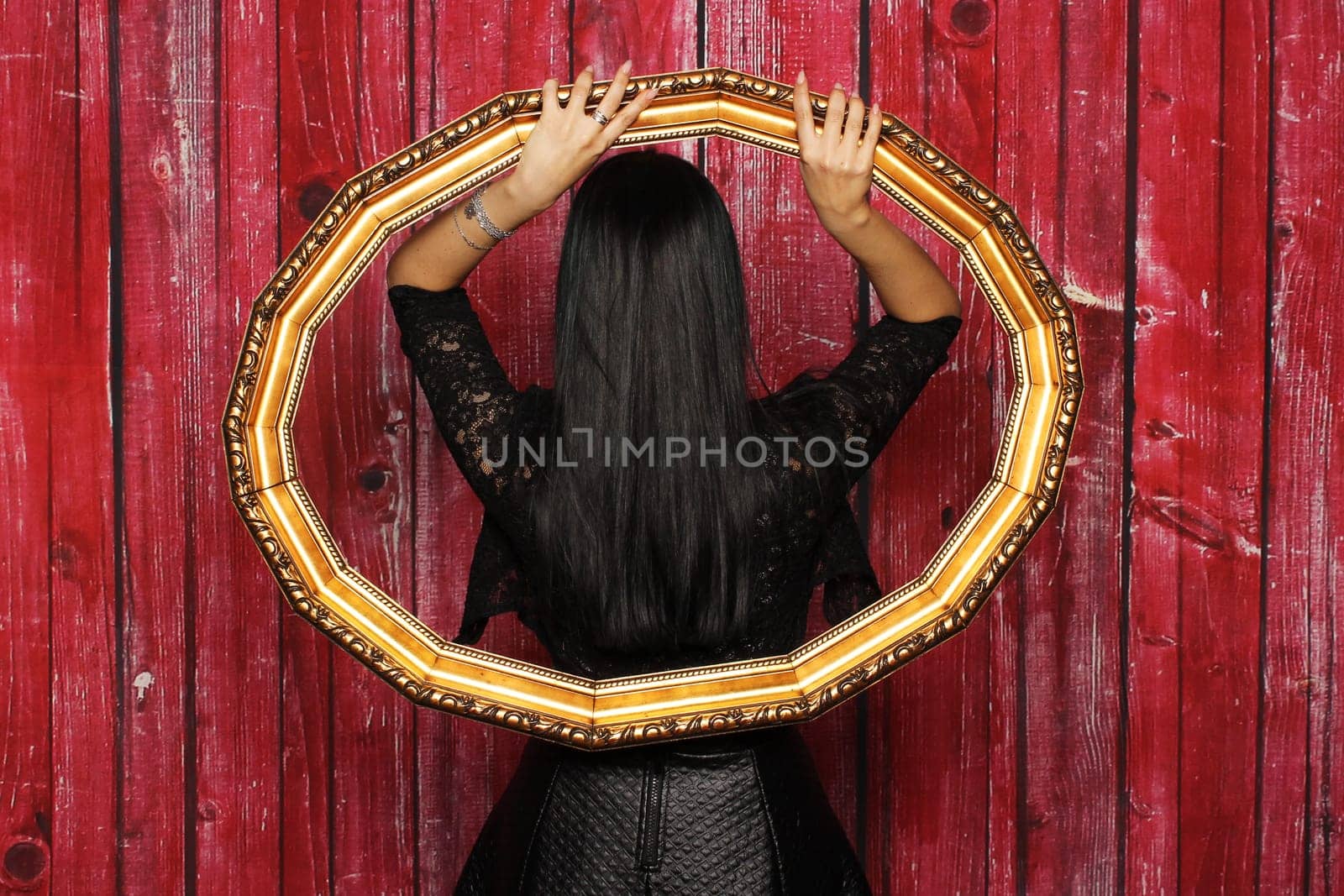 Mysterious woman stands with her back in a frame
