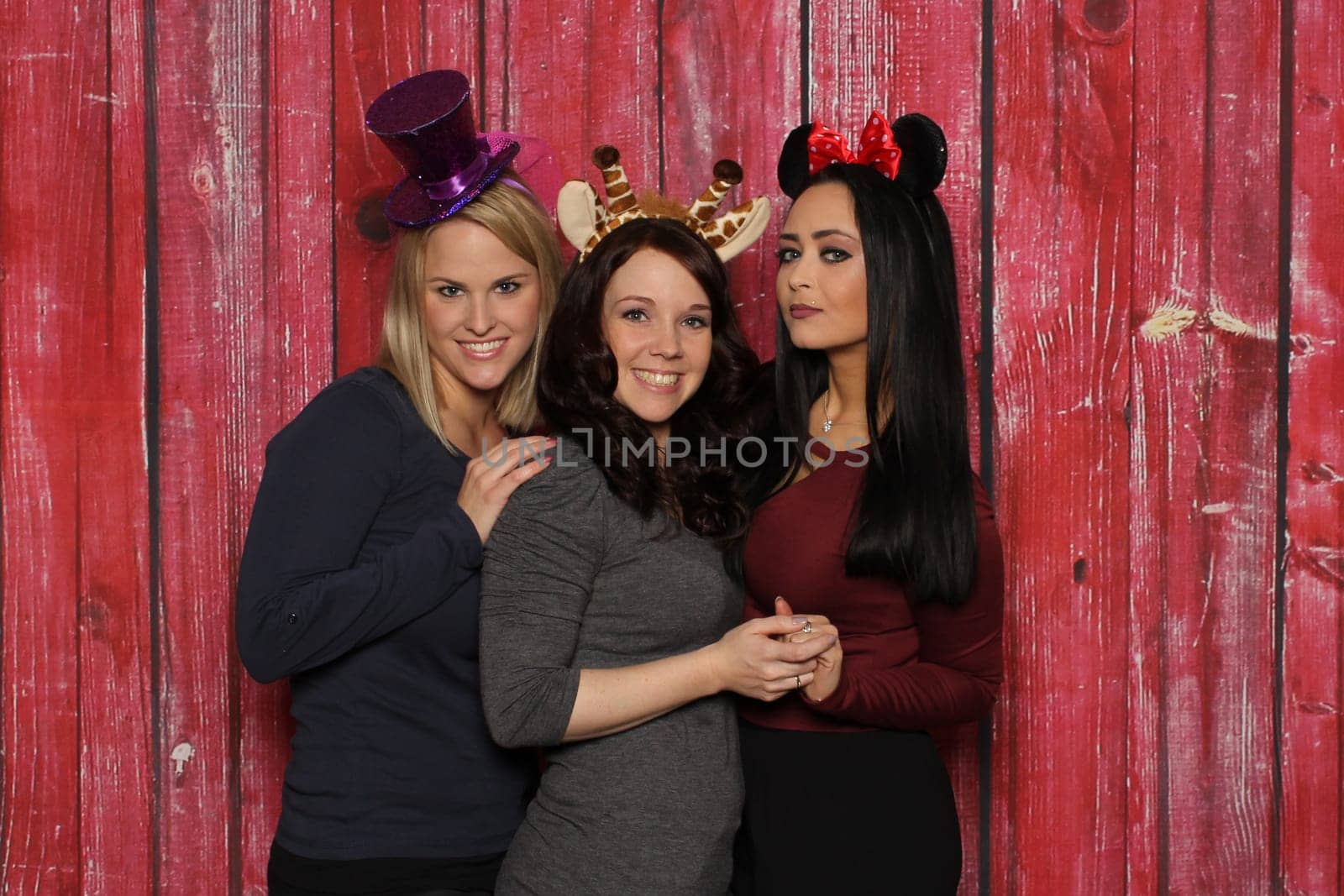 3 cute girls smiling in front of a photo booth