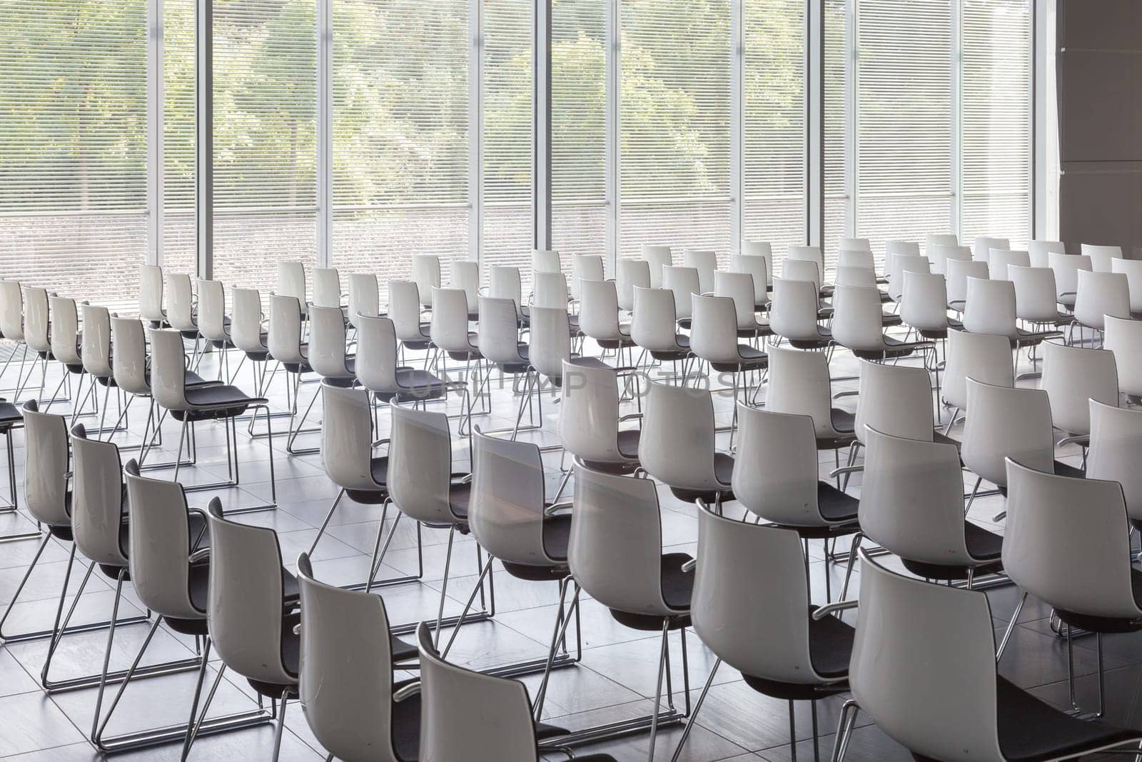 Interior of empty contemporary conference hall with white chairs.
