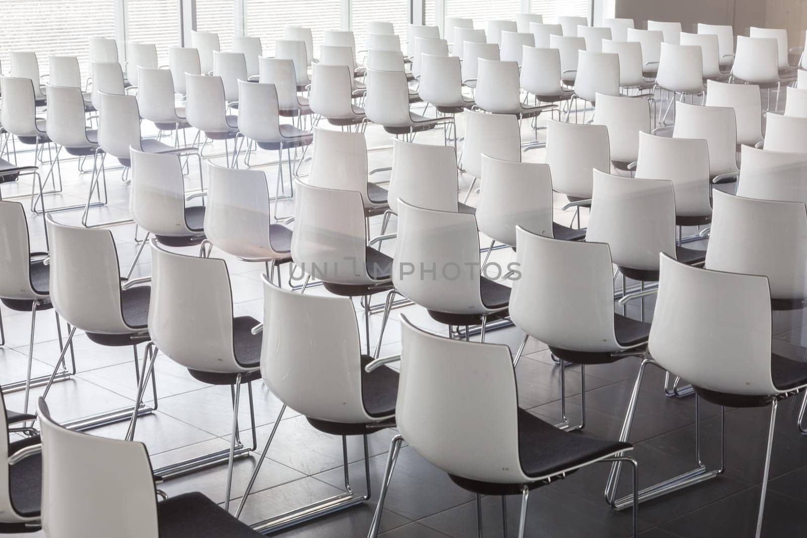 Interior of empty contemporary conference hall with white chairs.