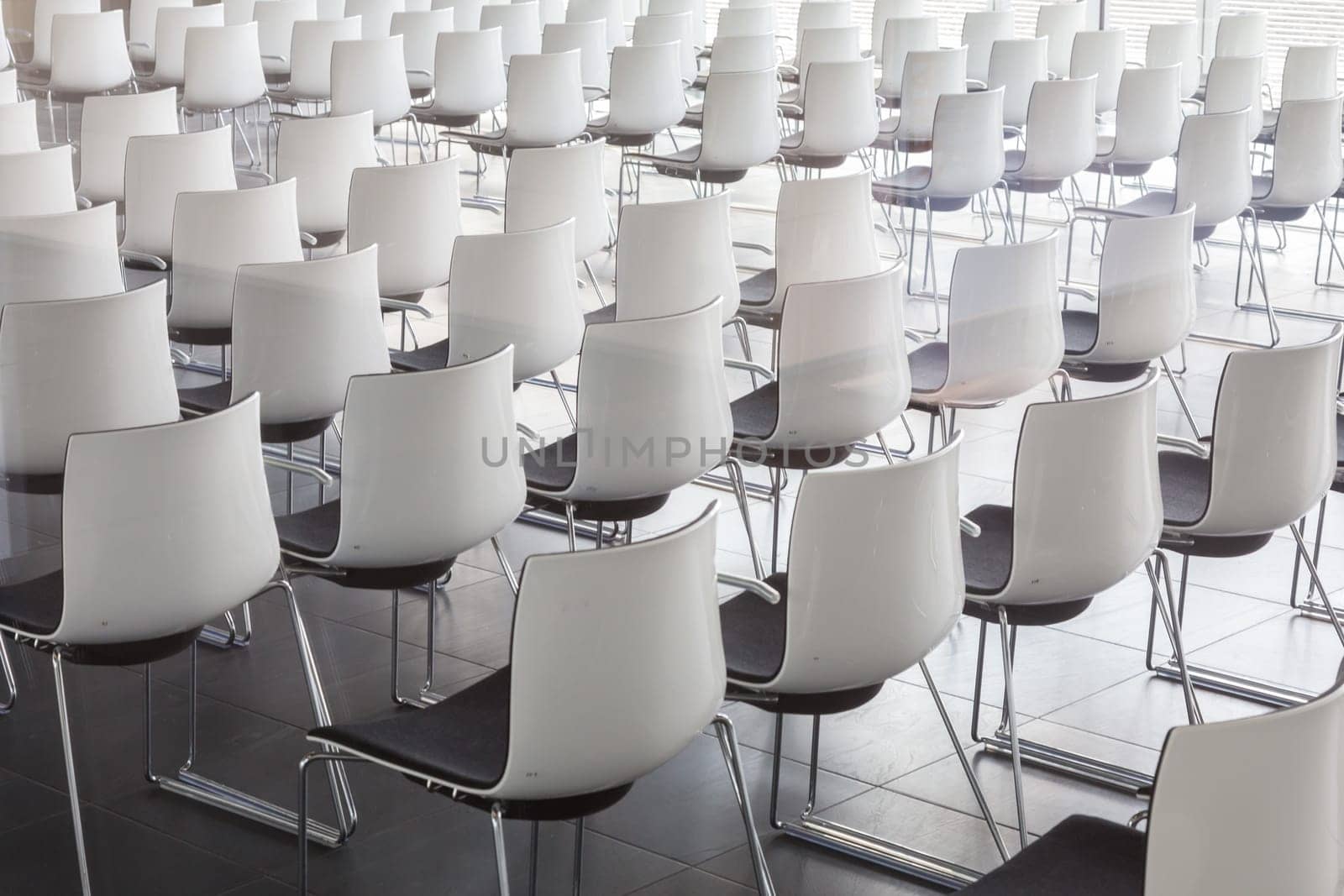 Interior of empty contemporary conference hall with white chairs.