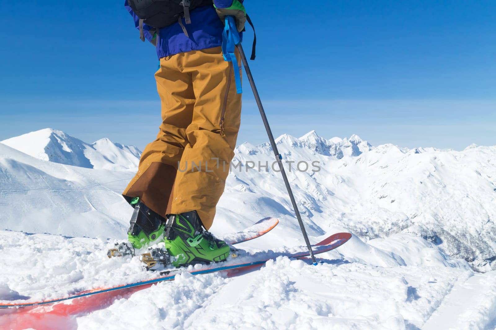 Freeride skier on the top of the mountain. Extreme winter freeride. Amazing landscape of snowy Alp mountains in the background. Vogel, Slovenia.