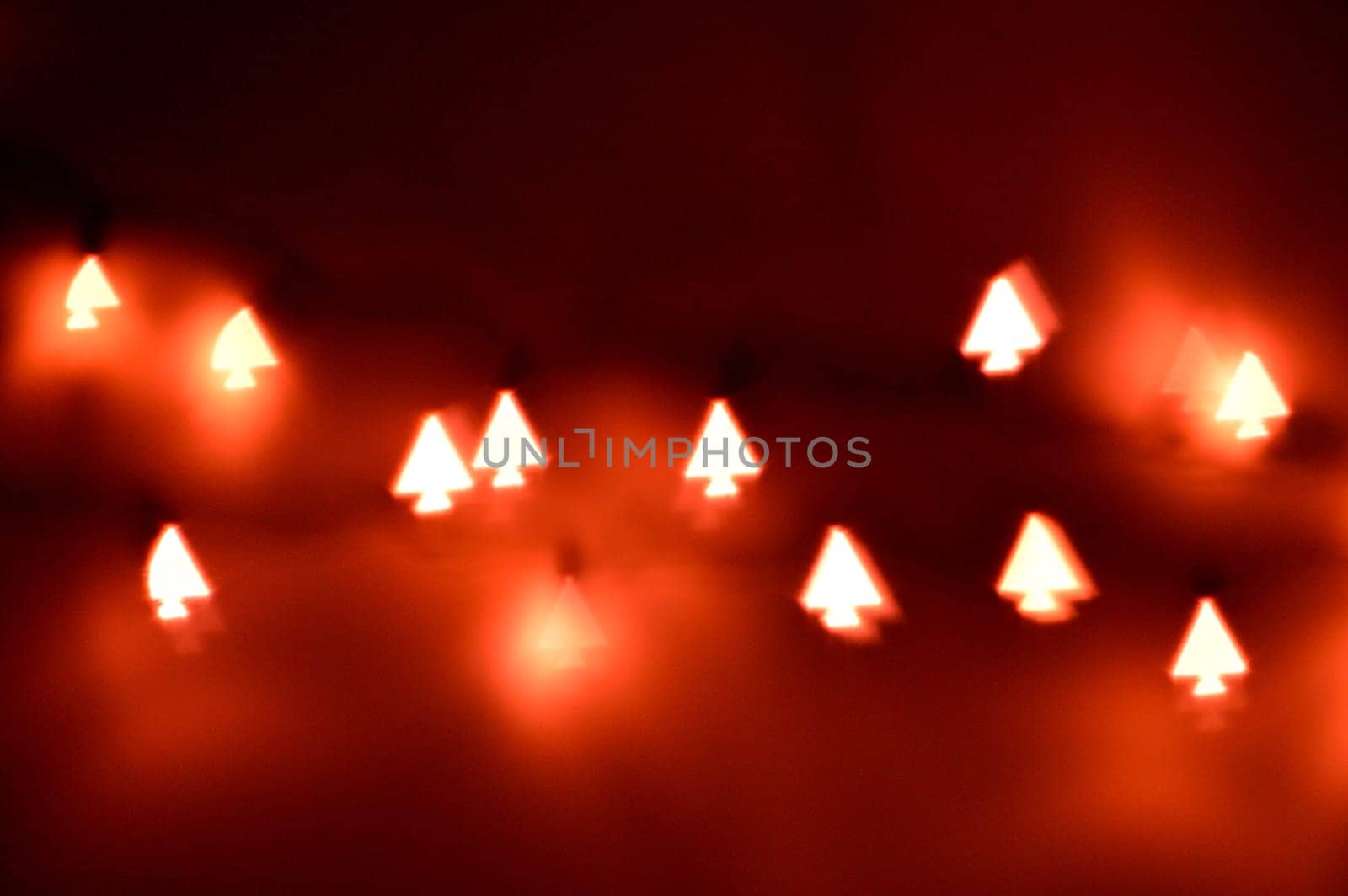 Bokeh Christmas lights in shapes of little Christmas trees. Happy Christmas time background.