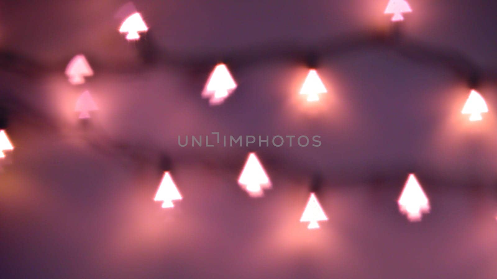 Bokeh Christmas lights in shapes of little Christmas trees. Happy Christmas time background.