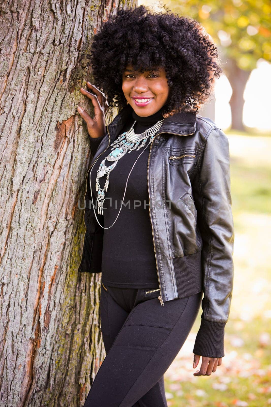 ethnic woman wearing fashion fall outfit outdoors int he park