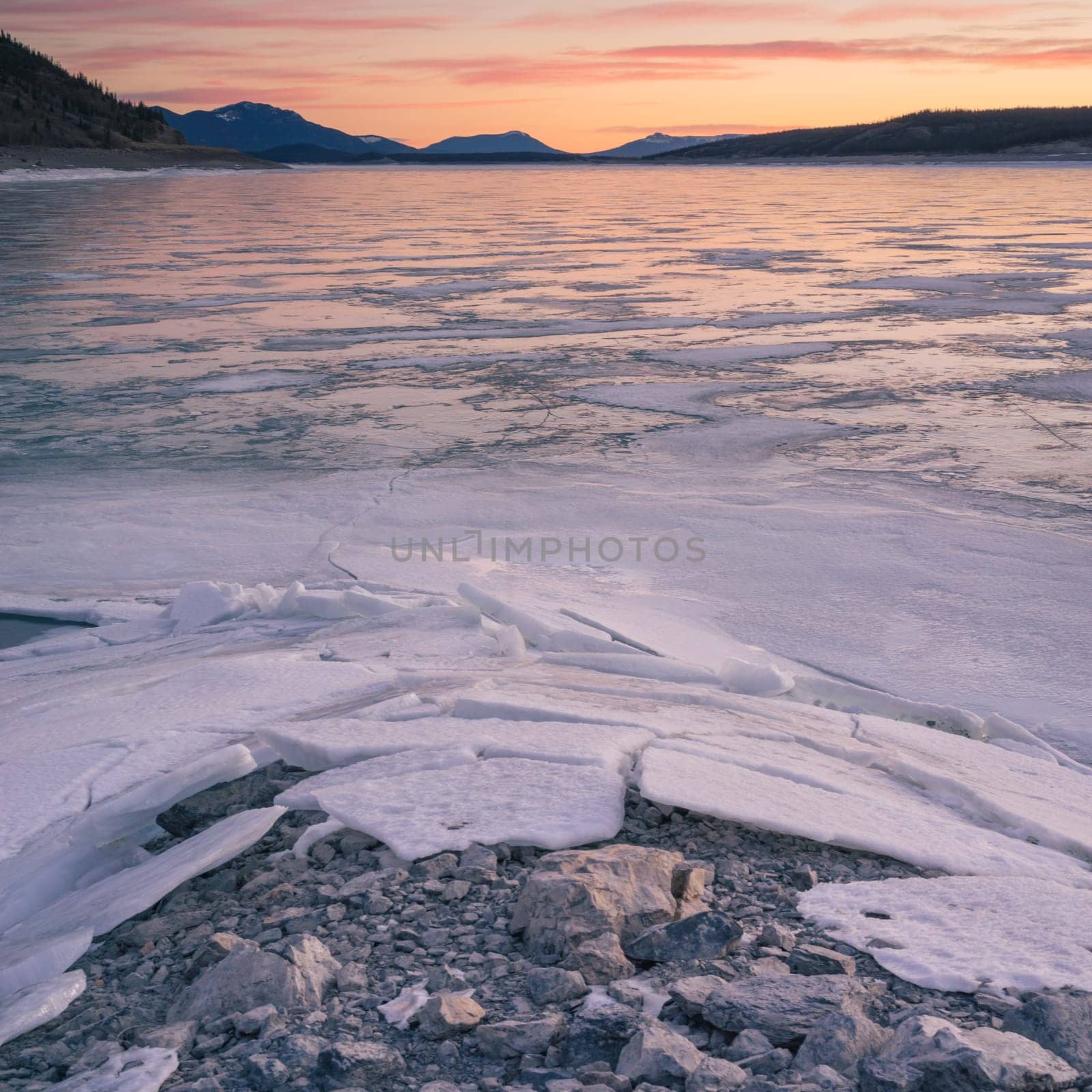 Landscape of frozen Abraham Lake with a rocky and Icy foreground, Alberta, Canada.