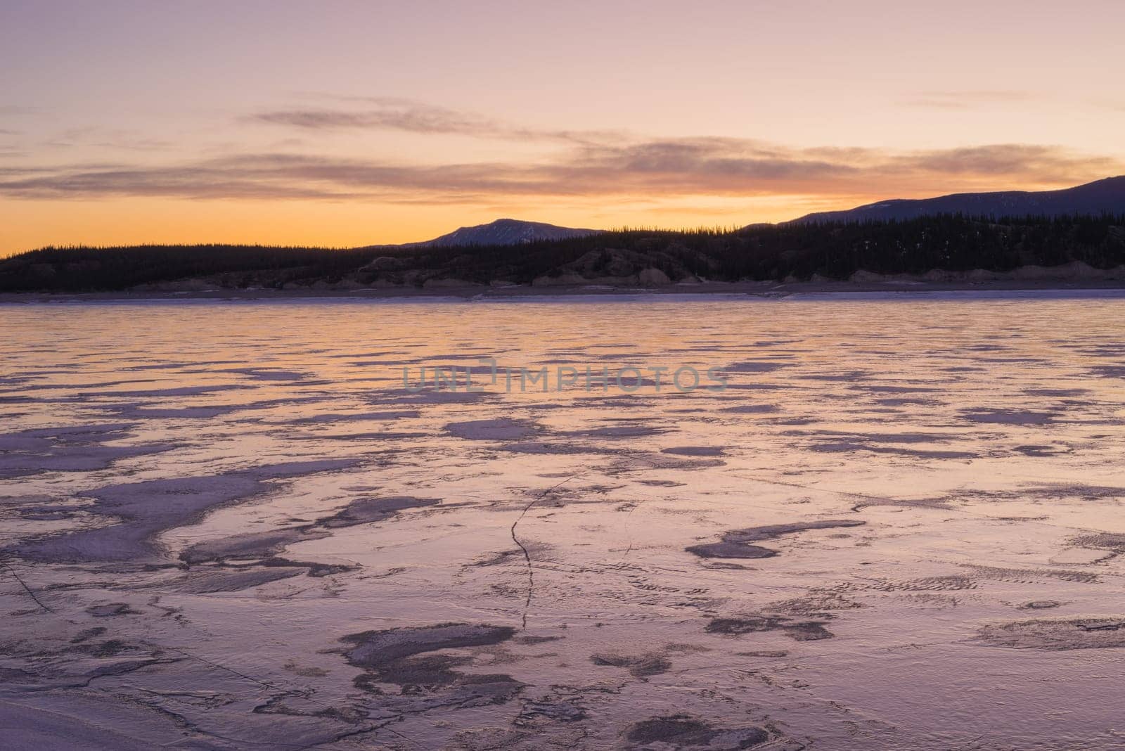 Warm tones of sunrise on Abraham Lake in Winter.