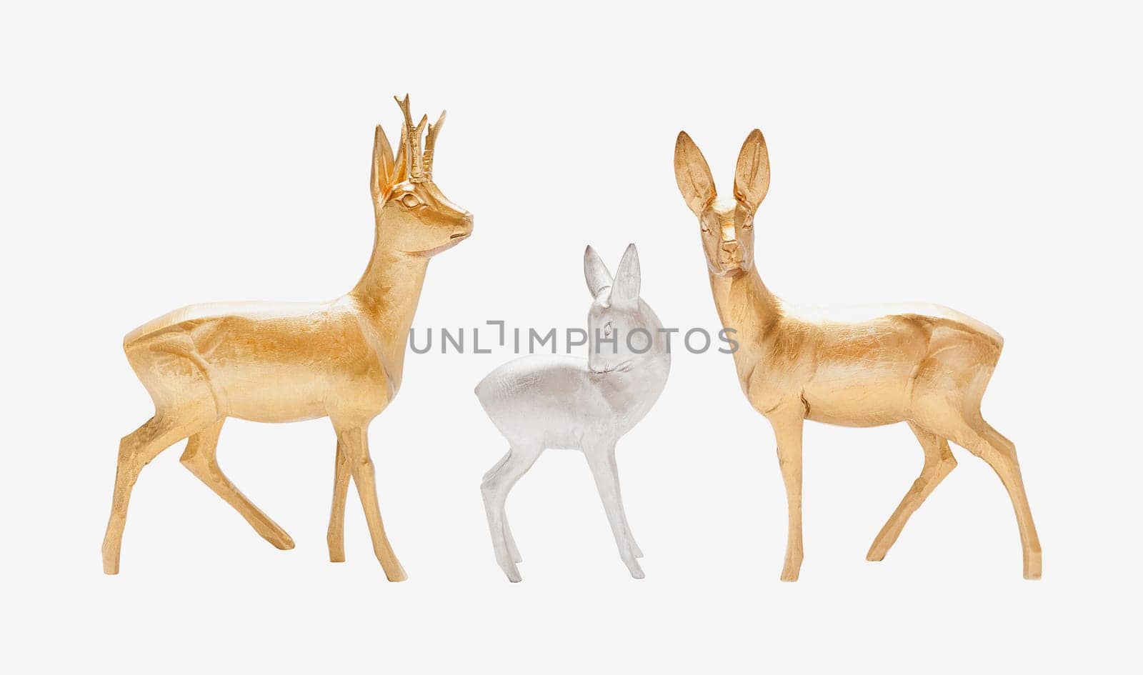 Male, female and young deer in gold and silver color carved in wood isolated