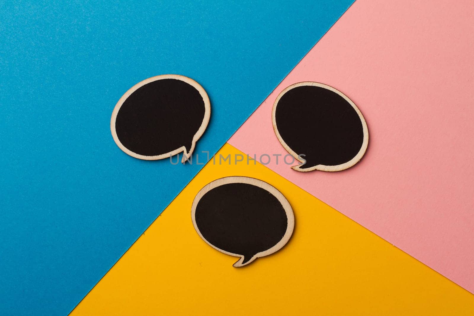 Top view of round chalk board speech bubbles on colored papers, metaphor, concept for communication