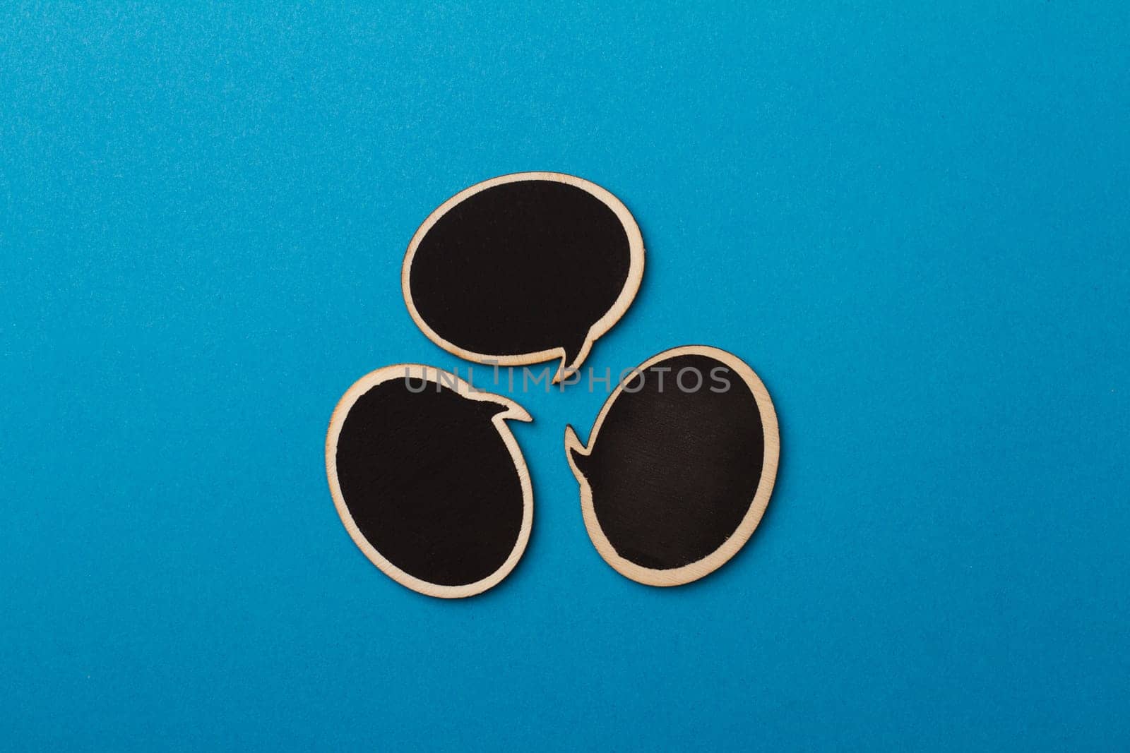 Top view of round chalk board speech bubbles on blue background, metaphor concept for communication
