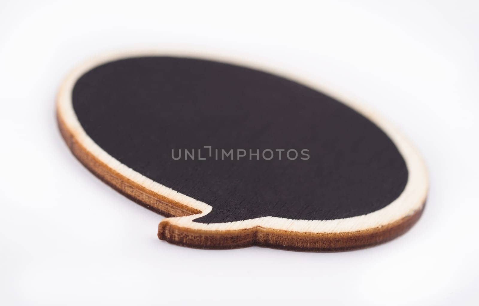 Macro of black handcrafted wooden blank speech bubble on white background