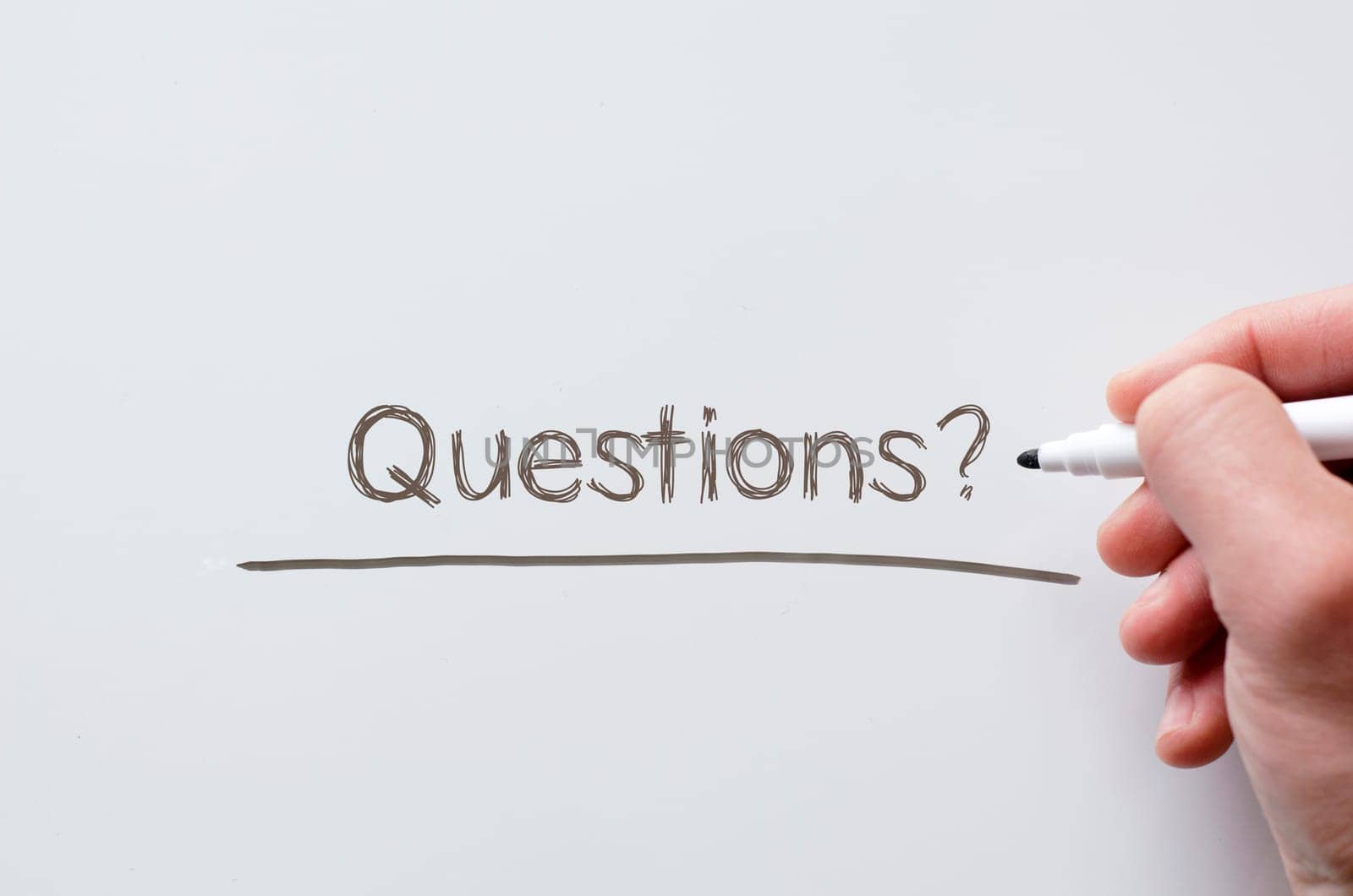 Human hand writing questions on whiteboard