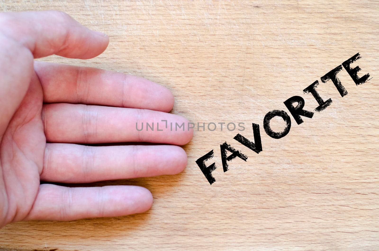 Human hand over wooden background and favorite text concept