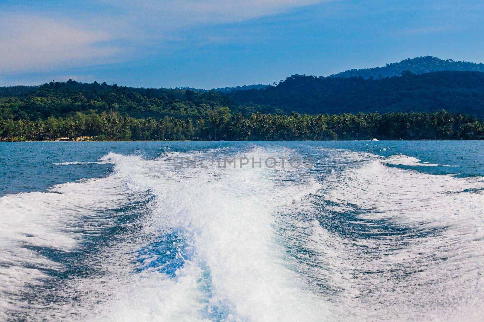 Water stream after speed boat.  Trail on water surface behind of fast moving motor boat. Waves on blue sea