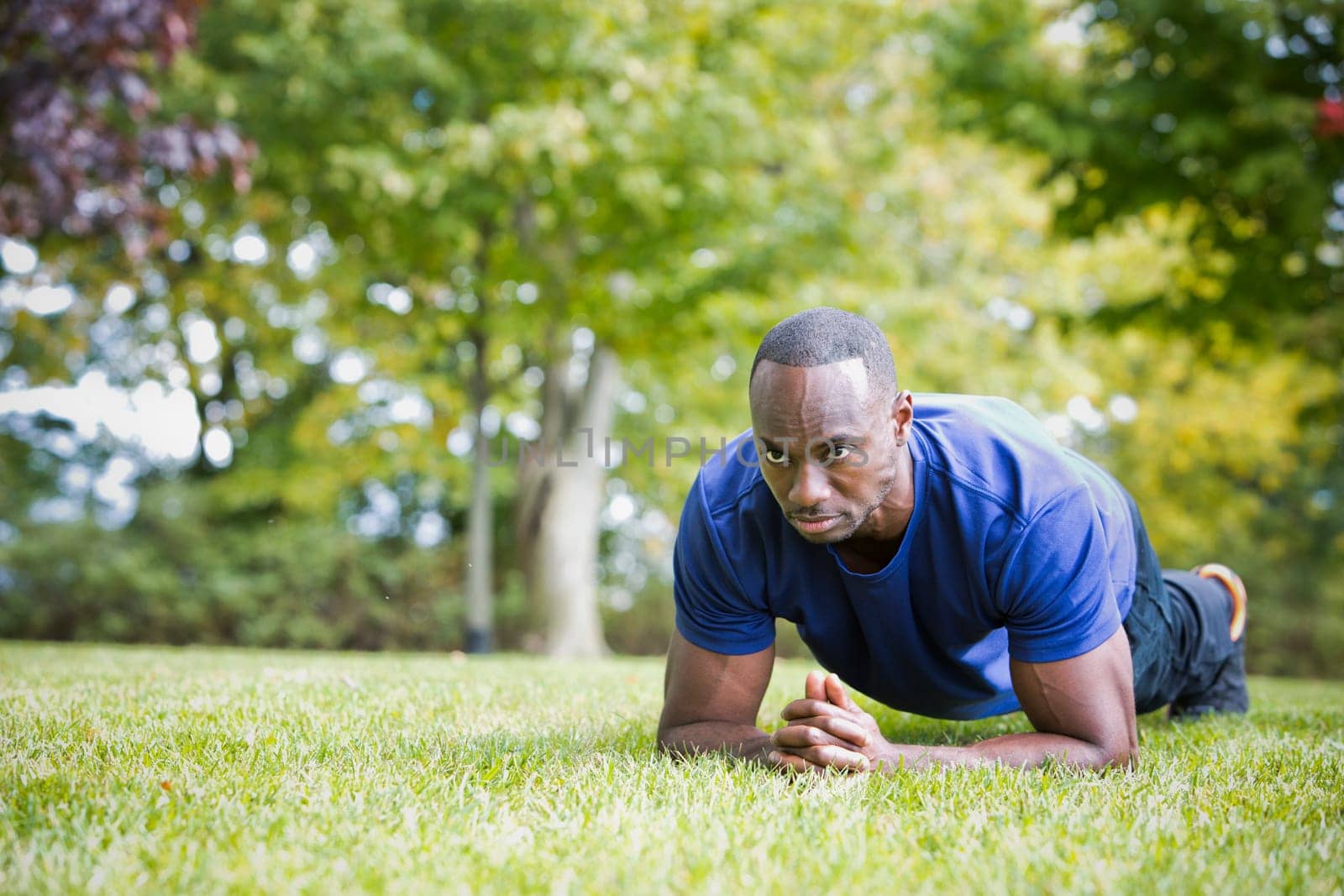 young black man wearing athletic wear doing exercise in the fall park