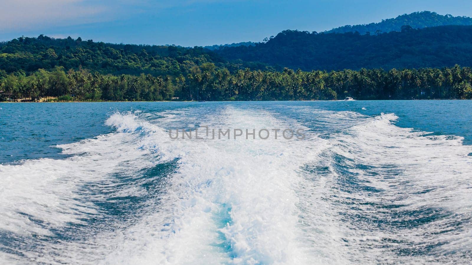 Water stream after speed boat.  Trail on water surface behind of fast moving motor boat. Waves on blue sea