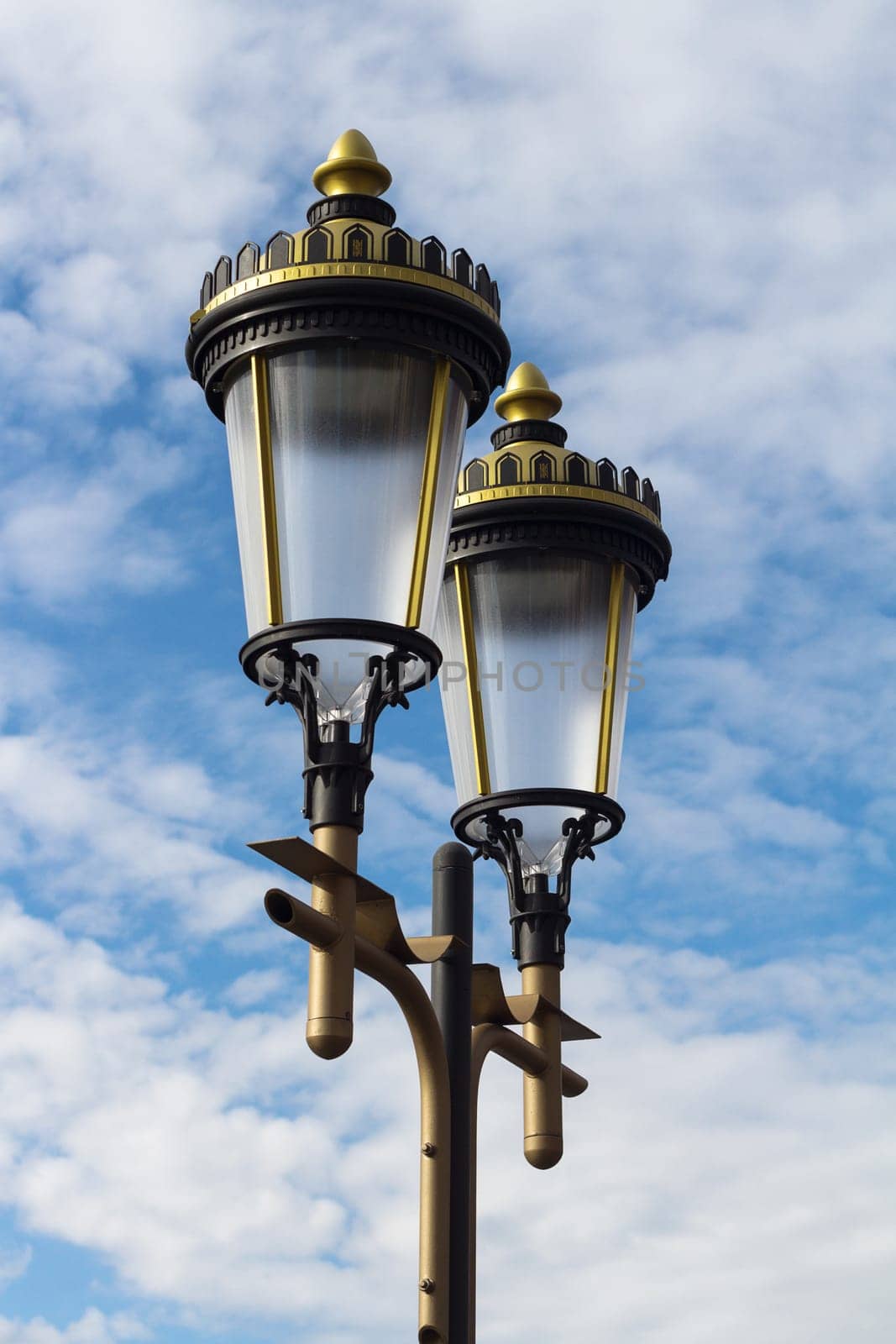 Classical design public illumination lights on blue sky with clouds
