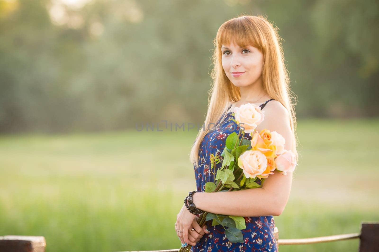 Beautiful girl standing on a river bridge with a bouquet of flowers. Portrait