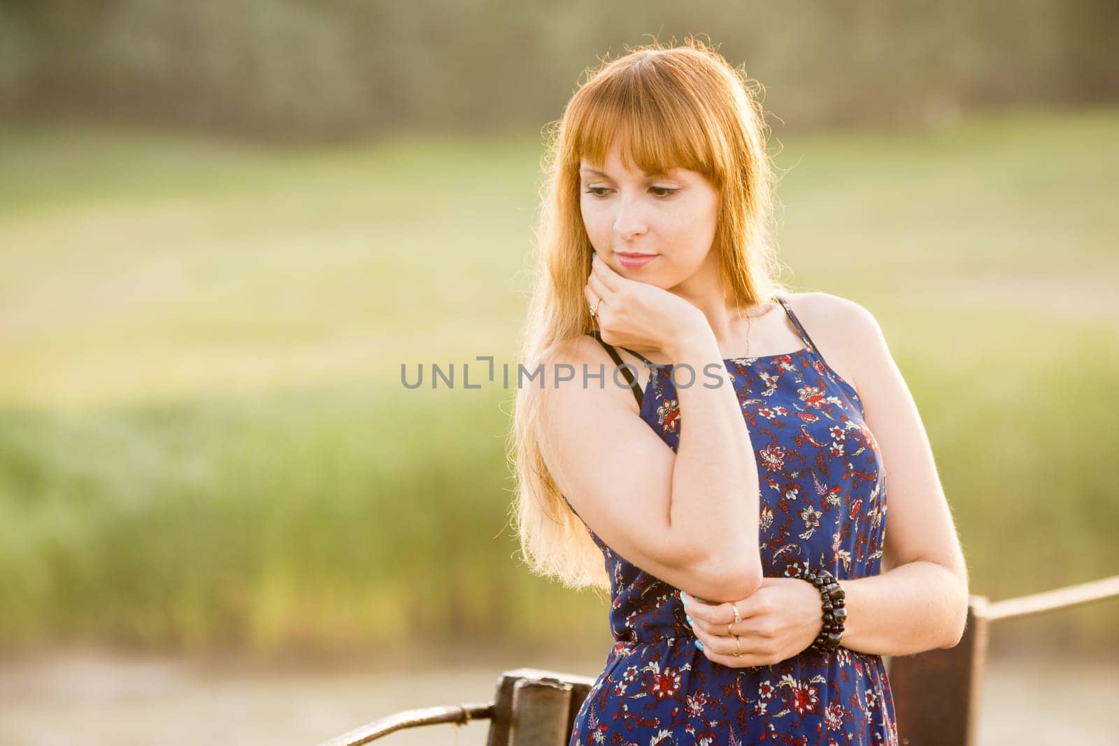 Portrait of a pensive modest girl on blurred green background