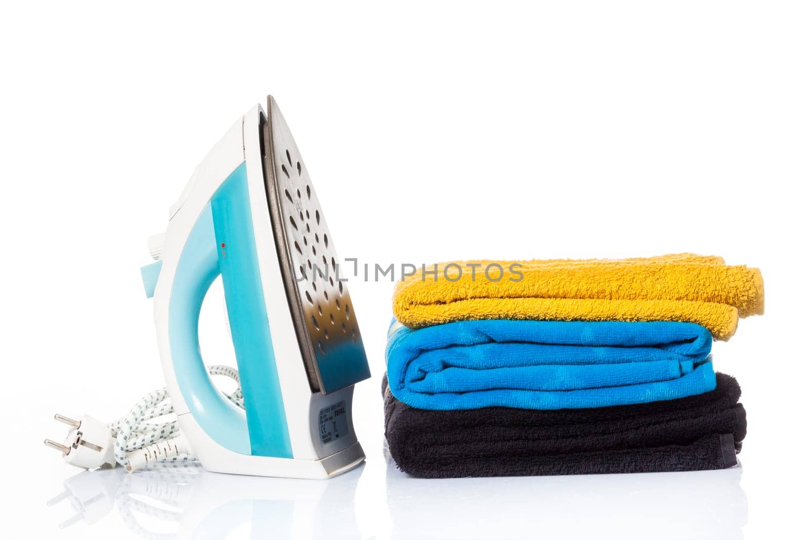 Electric iron and pile of clothes. electric iron isolated on white