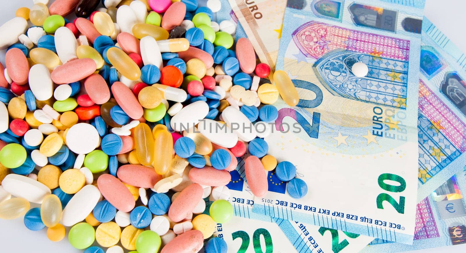 Pills of different colors on money