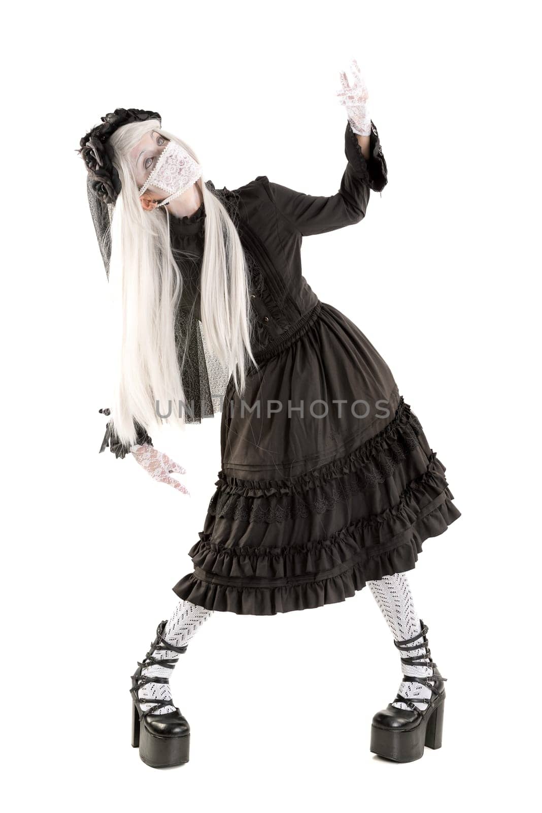 Widow in a black dress with white eyes looking like a doll isolated in white