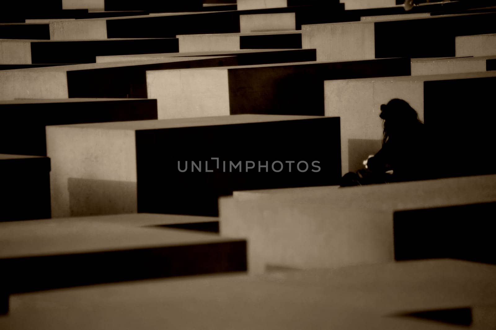 Berlin,Germany - May 10,2016: A tourist stands between the gray concrete blocks of the Memorial to the Murdered Jews of Europe on May 10,2016 in Berlin.
