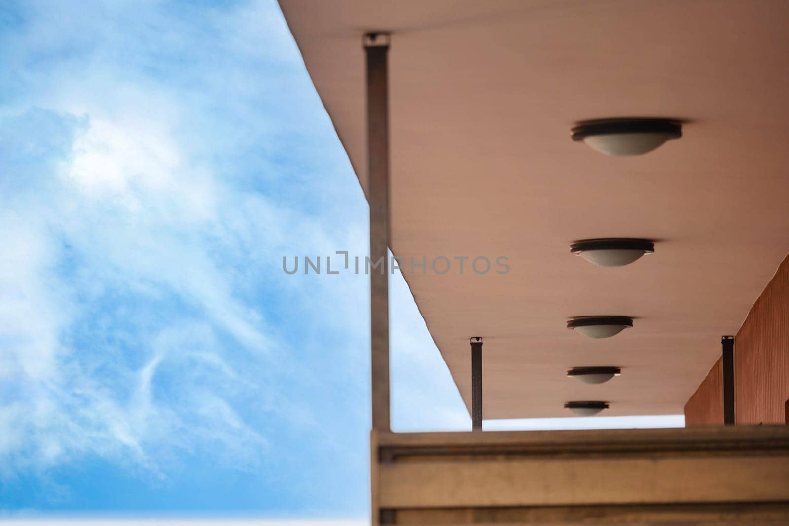 Unique lighting fixtures adorn a contemporary building's overhang.
