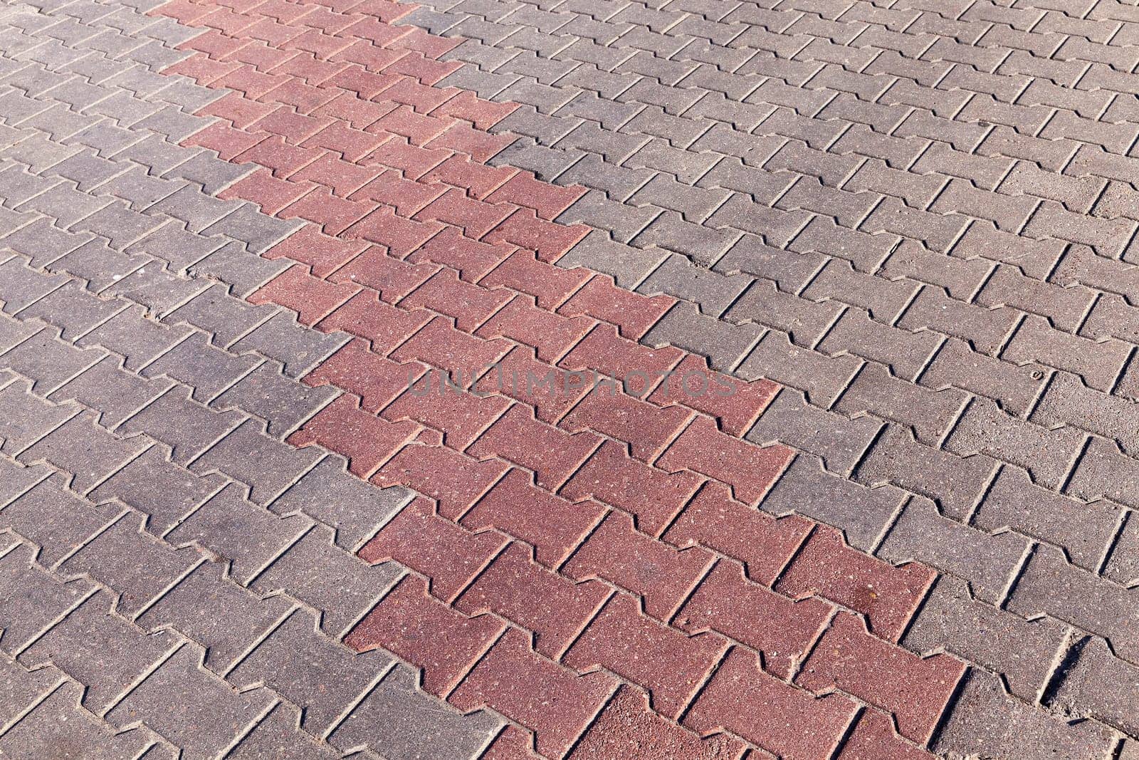 photographed close-up of road marking is located on the roadway, red line on the sidewalk tile