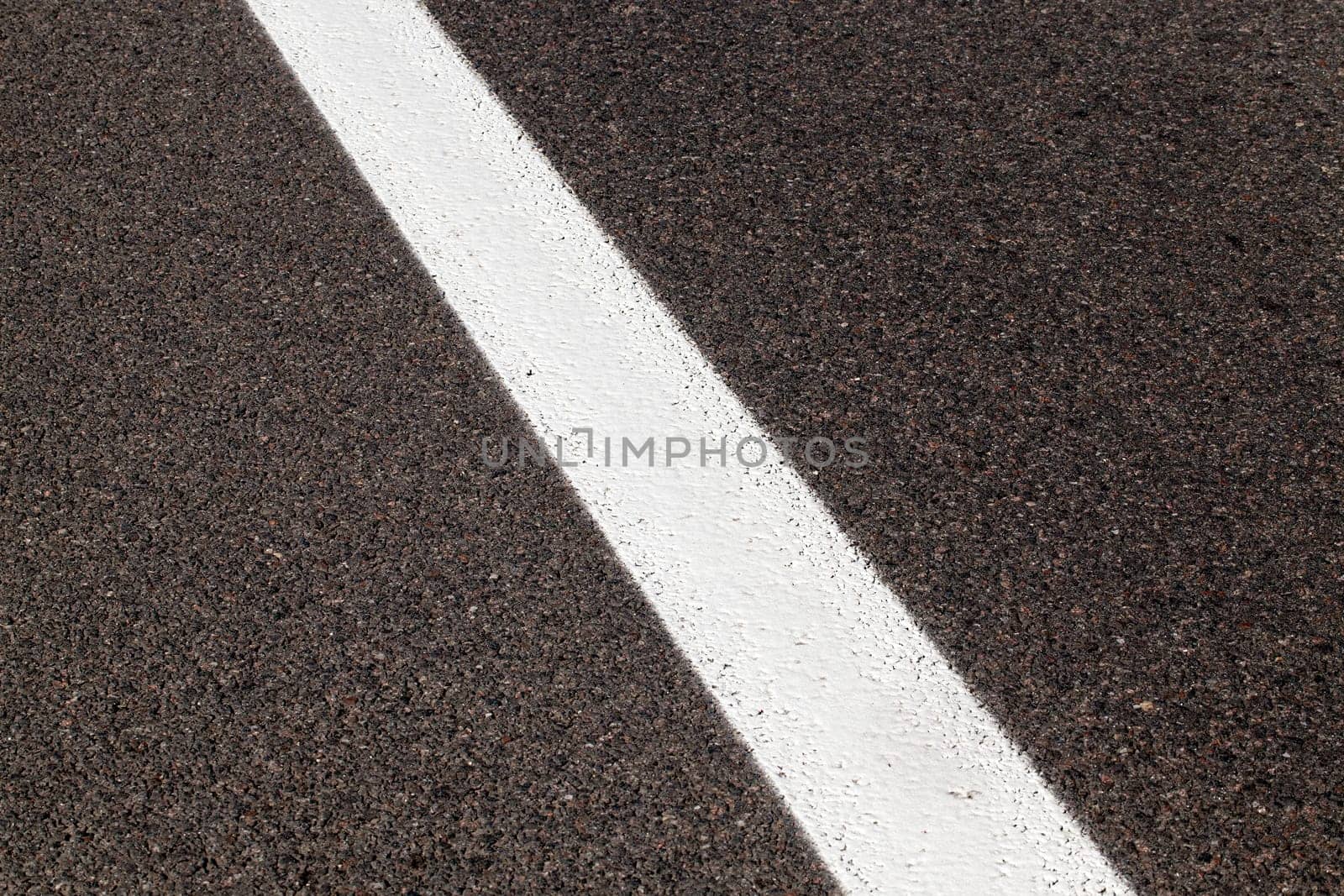 photographed close-up of road marking is located on the roadway, white line on the pavement
