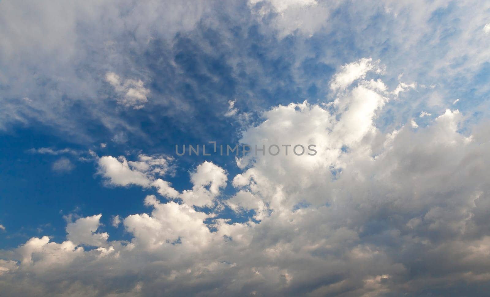 bright cumulus clouds are in the background of blue sky, close-up, de focus