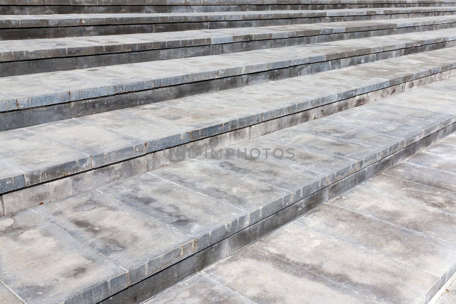 Photo broad steps made of concrete. Color gray structure, photographed at an angle and are visible plate