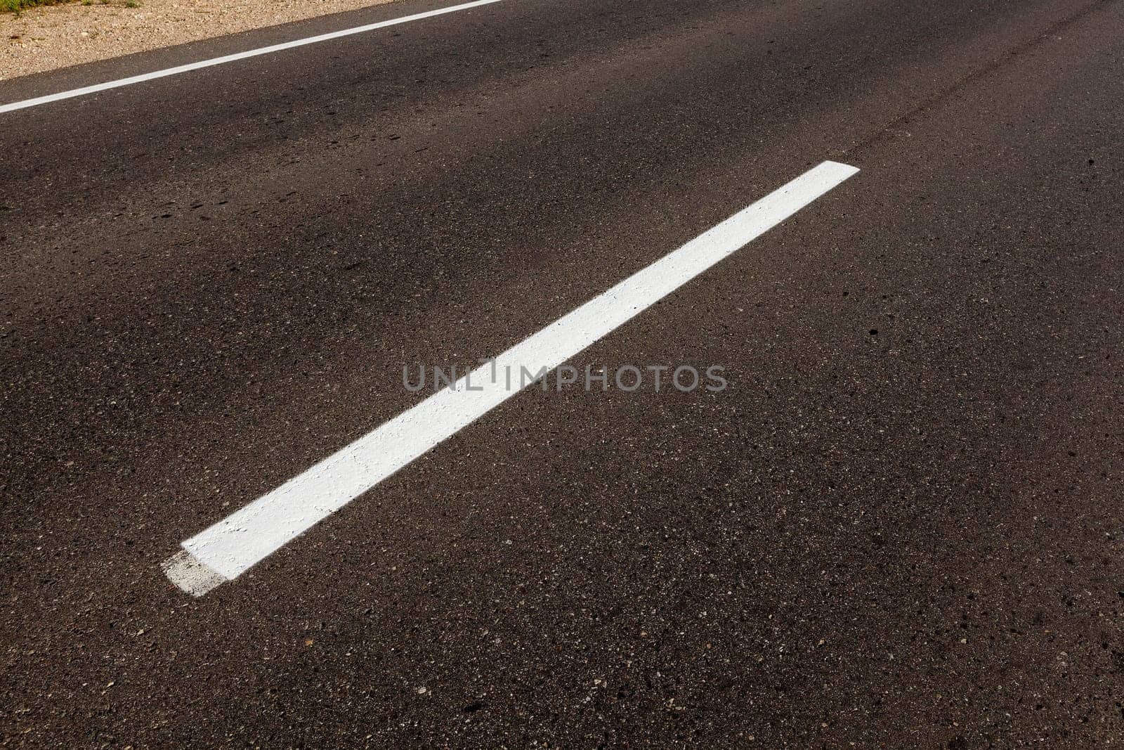 photographed close-up of road marking is located on the roadway, white line on the pavement