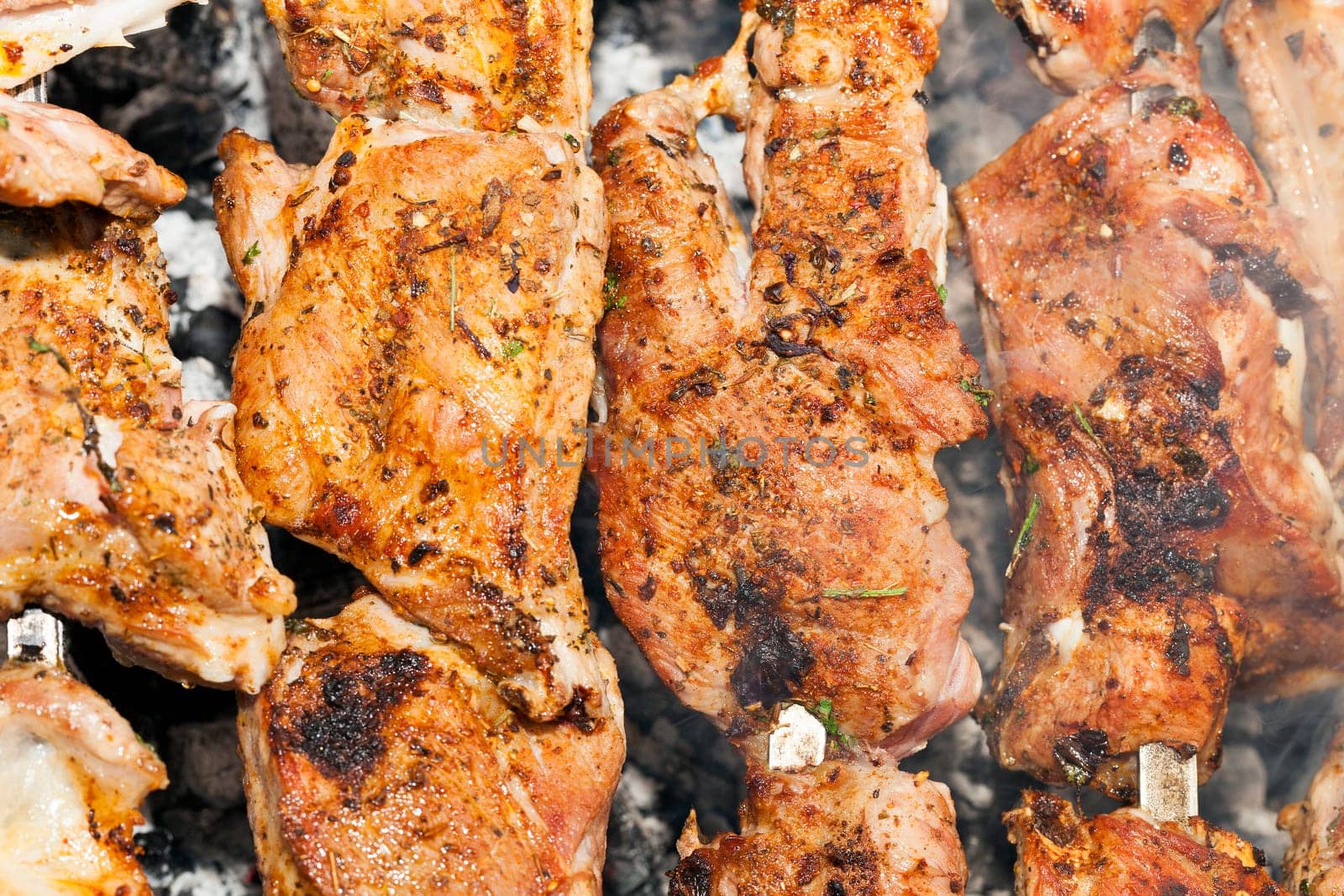 photographed close-up of pork meat pieces while cooking barbecue