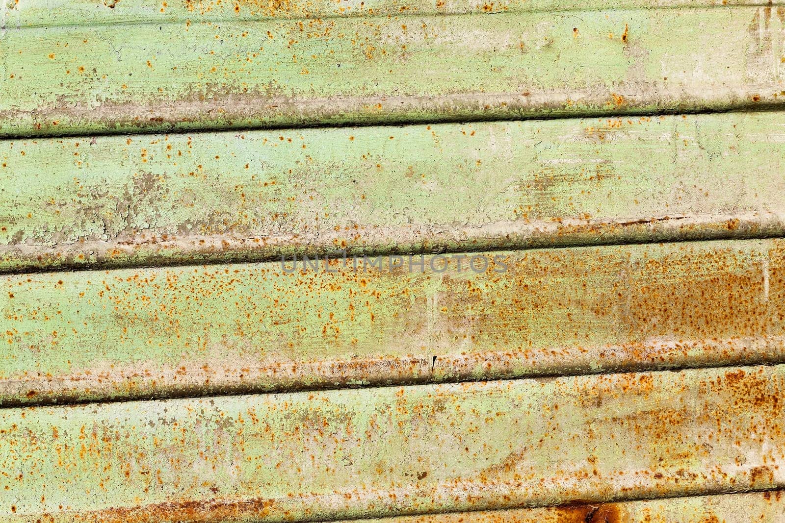 photographed close-up of a metal surface painted in green color, on which there was rust