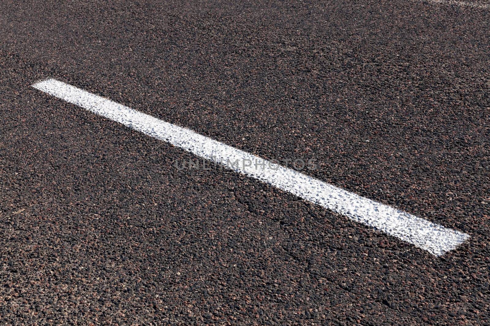photographed close-up of road marking is located on the roadway, white line on the pavement