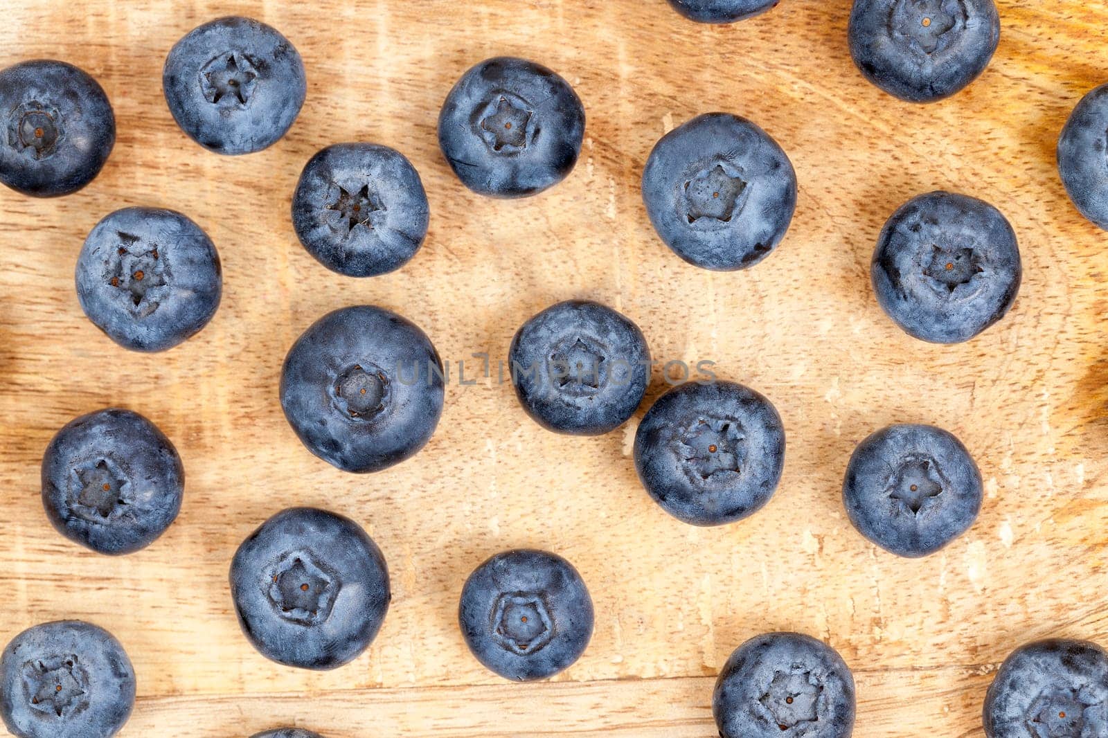 photographed closeup harvest ripe blueberries, berries spread out on an old wooden board, from top's photos