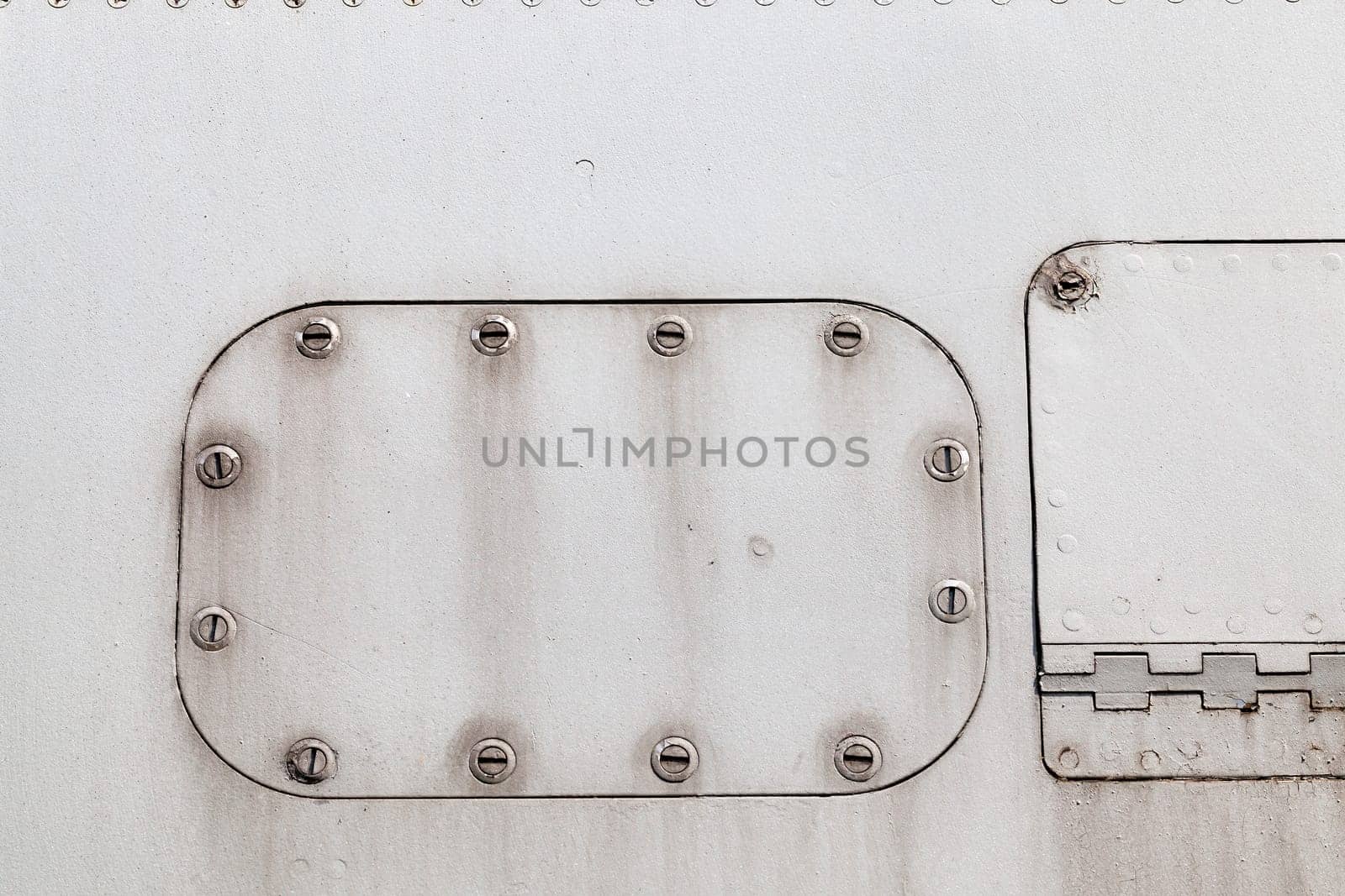 photographed close-up of an old lining of the aircraft. gray surface with screws, some of which are welded