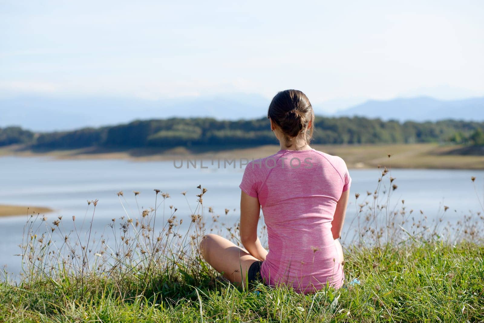 young sporty woman with a pink sportswear, back view
