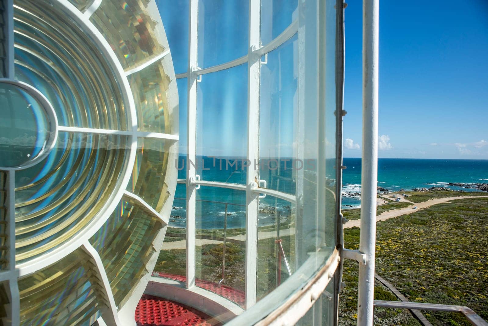 A view to the most Southern point of Africa from the top of a lighthouse with part of the light in view.