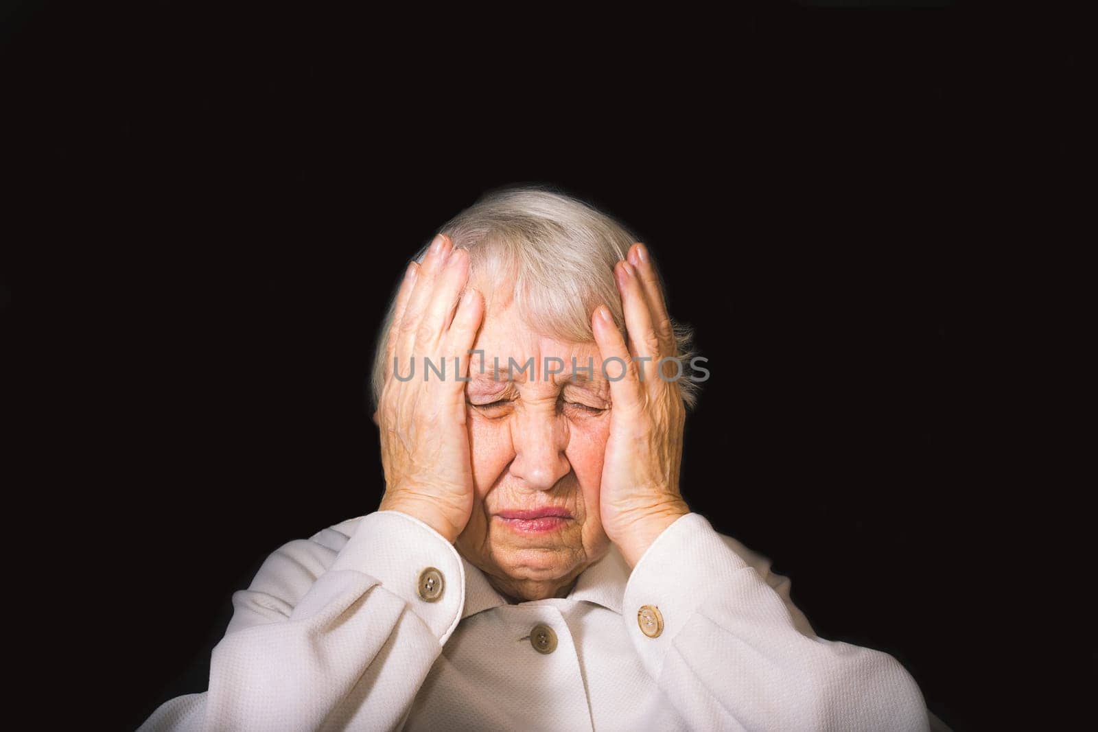 Senior Woman With Head In Hands Looking Weary on black