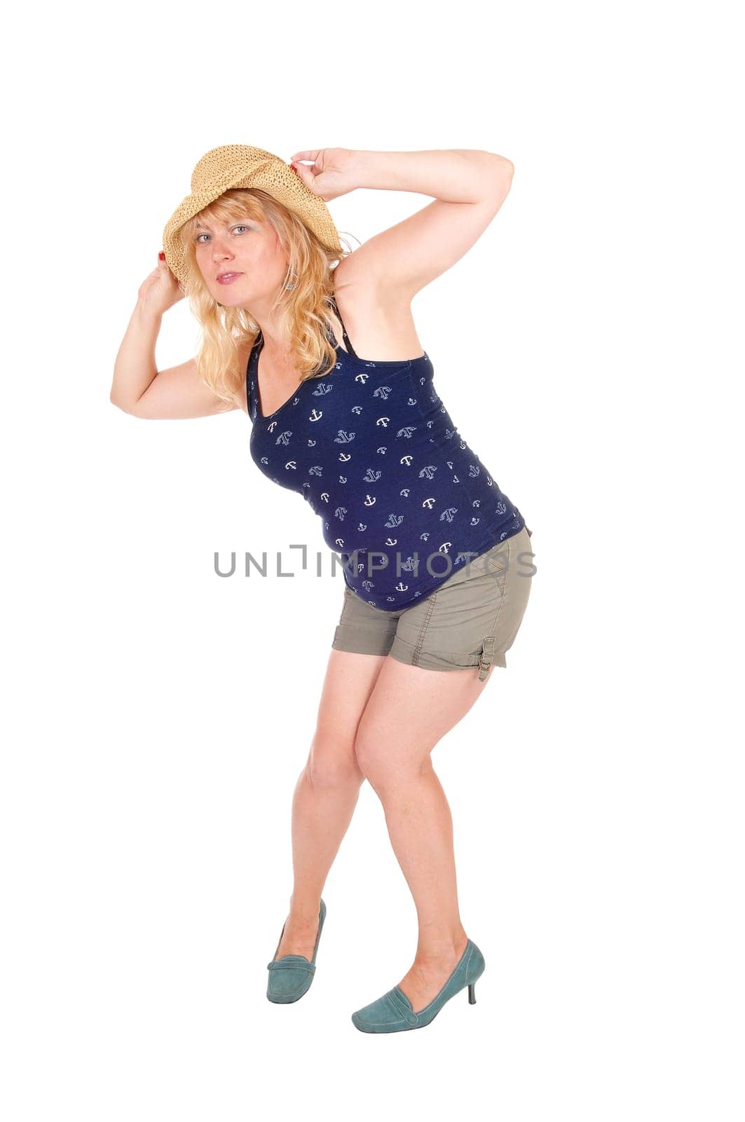 A pretty woman in shorts, holding a straw hat on her head,.isolated for white background..