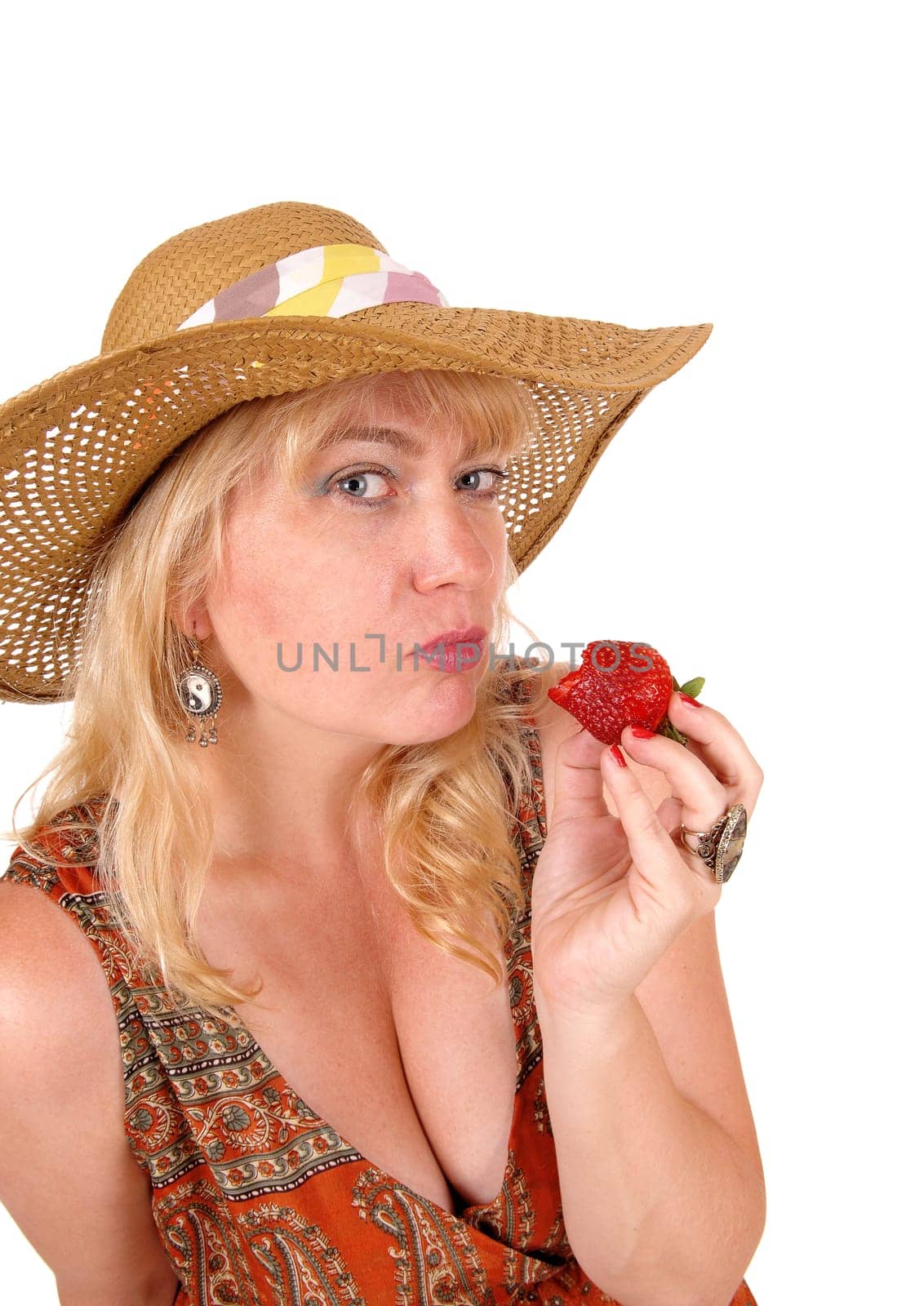 A closeup image of a nice woman eating a big strawberry with blue eye's.and a straw hat, isolated for white background..