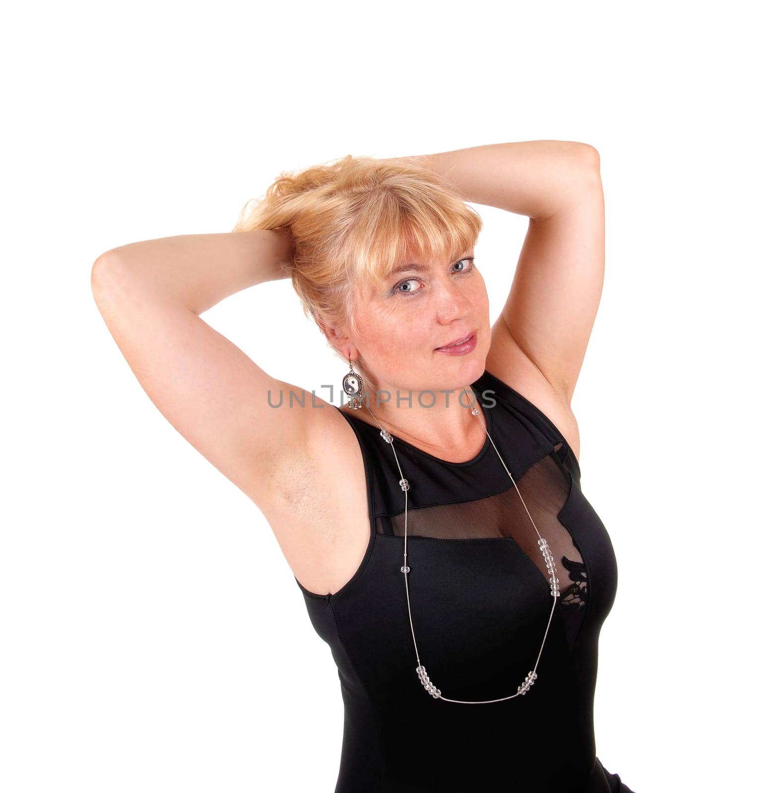 A portrait image of a pretty blond woman in a black dress with her .hands on her head, isolated for white background..